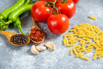 Fresh red tomatoes and chili peppers on marble background