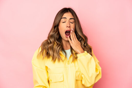 Young caucasian woman isolated yawning showing a tired gesture covering mouth with hand.