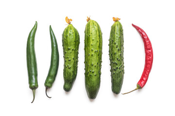 Fresh cucumbers and a few chili pods on a white background
