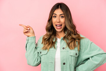 Young caucasian woman isolated smiling cheerfully pointing with forefinger away.