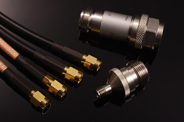 RF coaxial cables, attenuator and adapter isolated on black
