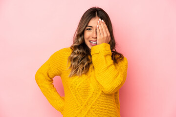 Young caucasian woman isolated having fun covering half of face with palm.