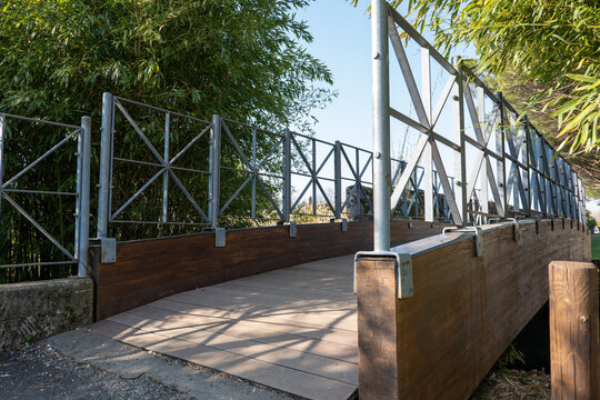 wooden bridge with iron railing across the river in the park