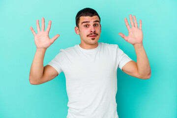 Fototapeta premium Young caucasian man isolated on blue background screaming to the sky, looking up, frustrated.