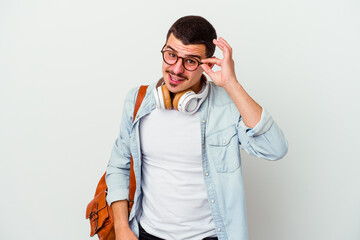 Young caucasian student man listening to music isolated on white background excited keeping ok gesture on eye.