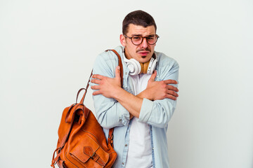 Young caucasian student man listening to music isolated on white background going cold due to low...
