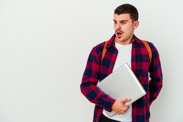 Young caucasian student man holding a laptop isolated on white background being shocked because of something she has seen.