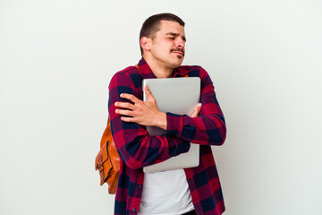 Young caucasian student man holding a laptop isolated on white background hugs, smiling carefree and happy.