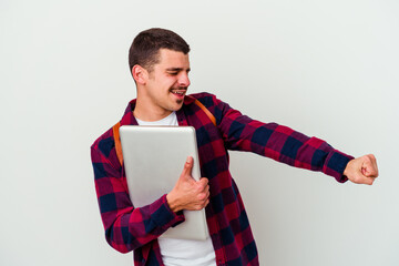 Young caucasian student man holding a laptop isolated on white background dancing and having fun.