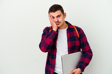 Young caucasian student man holding a laptop isolated on white background who is bored, fatigued and need a relax day.