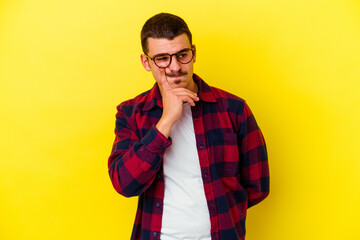 Young caucasian cool man isolated on yellow background contemplating, planning a strategy, thinking about the way of a business.