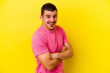 Young caucasian cool man isolated on yellow background laughing and having fun.