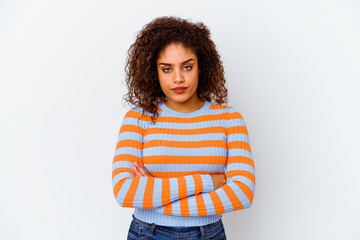 Young african american woman isolated on white background frowning face in displeasure, keeps arms...