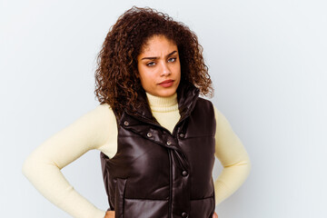 Young african american woman isolated on white background frowning face in displeasure, keeps arms folded.