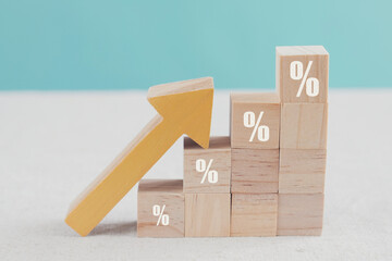 Wooden blocks with percentage sign and arrow up, financial growth, interest rate increase,...