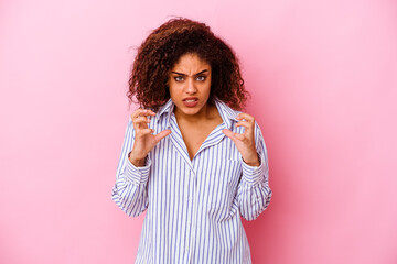 Young african american woman isolated on pink background upset screaming with tense hands.