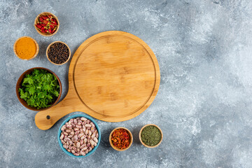 Variety of spices, vegetables and raw beans on blue background