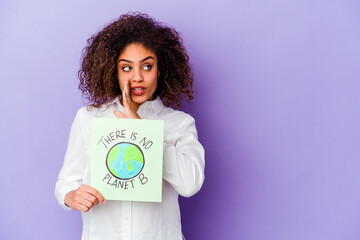 Young African American woman holding a There is no planet B placard isolated is saying a secret hot braking news and looking aside