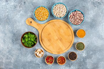 Obraz na płótnie Canvas Variety of spices, vegetables and raw beans on blue background