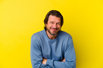 Middle age caucasian man isolated on yellow background laughing and having fun.
