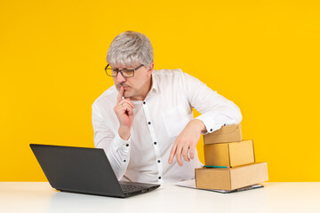 Employee of logistics center is puzzled by something. Man looks at laptop screen. Concept - he...