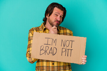 Middle age man holding a banner saying that he is not a famous person