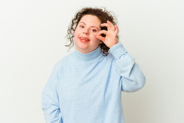 Woman with Down syndrome isolated excited keeping ok gesture on eye.