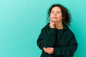 Woman with Down syndrome isolated looking sideways with doubtful and skeptical expression.