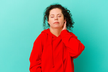Fototapeta na wymiar Woman with Down syndrome isolated having a neck pain due to stress, massaging and touching it with hand.