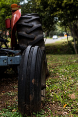 Fototapeta premium Worn out tyres of a very old red tractor