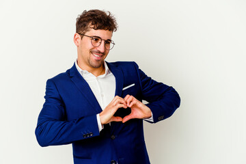 Young business caucasian man isolated on white background smiling and showing a heart shape with hands.