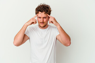 Fototapeta na wymiar Young caucasian man isolated on white background focused on a task, keeping forefingers pointing head.