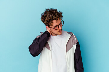 Young caucasian man wearing eyeglasses isolated on blue background having a neck pain due to stress, massaging and touching it with hand.