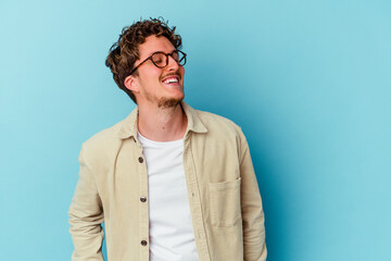 Fototapeta premium Young caucasian man wearing eyeglasses isolated on blue background relaxed and happy laughing, neck stretched showing teeth.