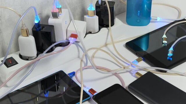 Connect Smartphone Mobile Phone and tablets connected to Charging hub on the Table, micro usb   wires to chargers in sockets with LED light Blinking. Extension cord switch loaded with Charger 