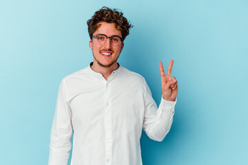 Fototapeta premium Young caucasian business man isolated on blue background showing victory sign and smiling broadly.