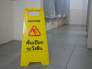 caution wet floor sign at public toilet.
