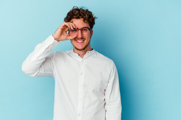 Obraz premium Young caucasian business man isolated on blue background excited keeping ok gesture on eye.