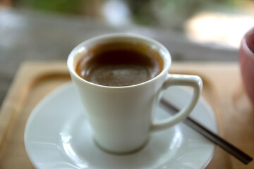 Blurred coffee cup placed on a wooden table