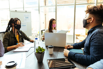 Business team wearing protective masks while meeting in the office during the COVID-19 epidemic