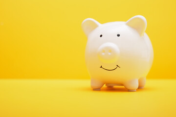 White piggy bank on yellow background. Saving money wealth and financial concept