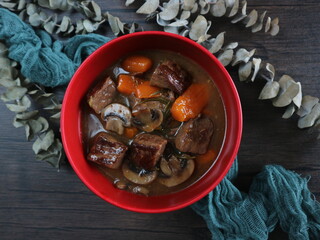 Homemade Boeuf Bourguignon flatlay on wooden table. Beef stew still life, dark food photography with copy space.