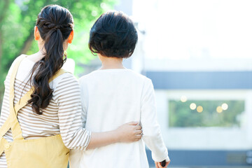 シニア女性の歩行を介助する女性介護士の後ろ姿