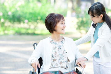 車椅子に乗った祖母と話す孫娘