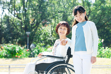 車椅子に座る祖母と笑顔の孫娘