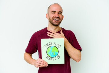 Young caucasian bald man holding a there is not planet B placard isolated on purple background laughs out loudly keeping hand on chest.