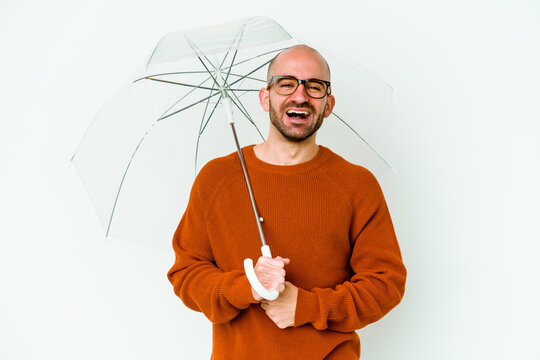 Young Bald Man Holding An Umbrella Isolated Laughing And Having Fun.