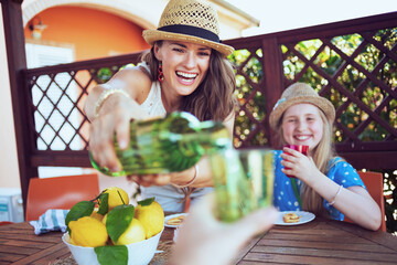 smiling trendy mother and daughter having lunch