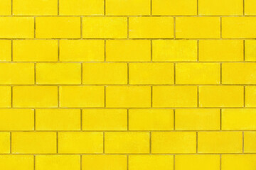 Yellow paint on a bright brick blocks urban color wall texture background