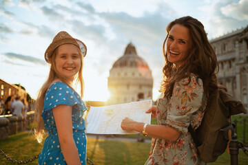 happy elegant mother and daughter with map sightseeing